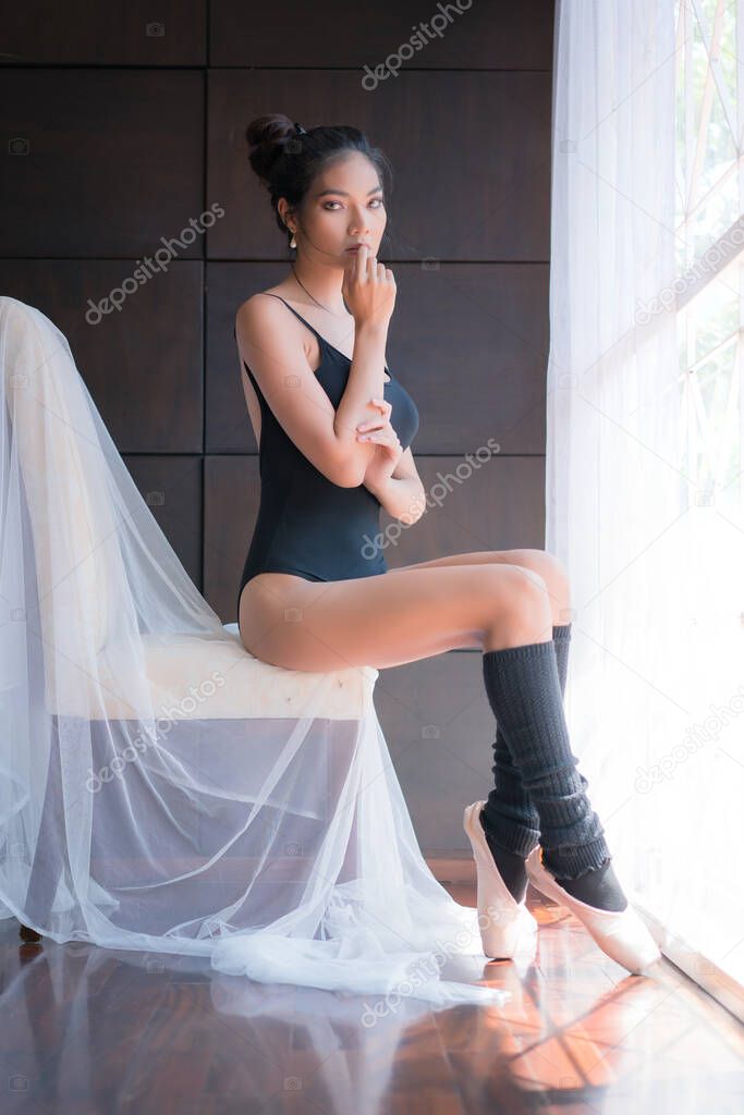 Beautiful young ballerina and pointe shoes is ballet dancers in room.