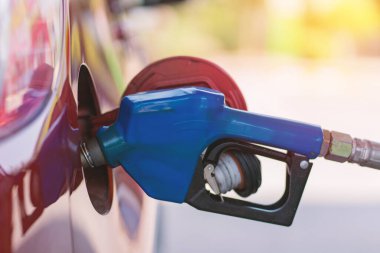 Benzin istasyonunda benzini doldurulmuş bir araba, bir motorlu taşıt arabasına dizel ya da benzin dolduruluyor..