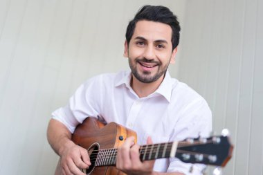 Oturma odasında kanepede oturup evde kaygısız vakit geçiren mutlu bir adam..