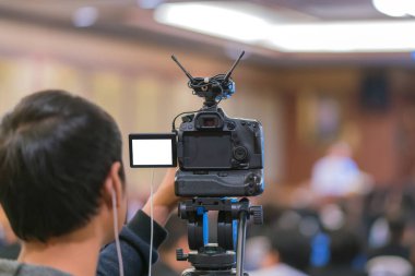 Kameraman Vedio 'yu konferans salonunda ya da seminer salonunda konuşma yapmaya götürüyor.