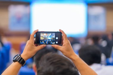Konferans salonunda ya da seminer salonunda, etkinlik ve seminer konseptinde sahnedeki konuşmacının fotoğraf çekmesi.