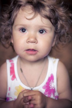 Kamera gülümseyen karanlık arka planda bebek kız gülüyor. yakın çekim portre. Bebek kamera gülümsüyor