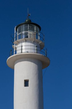 Deniz fenerinin beyaz kulesi ve mavi gökyüzü