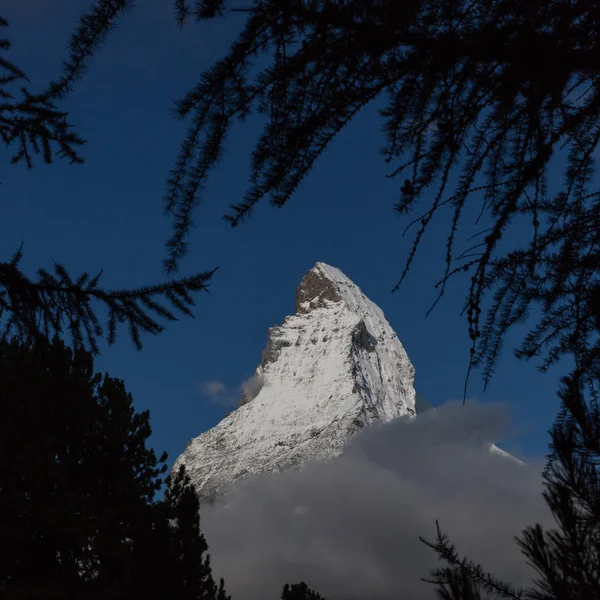 Matterhorn cumbre en el cielo azul visto aunque árboles — Foto de Stock