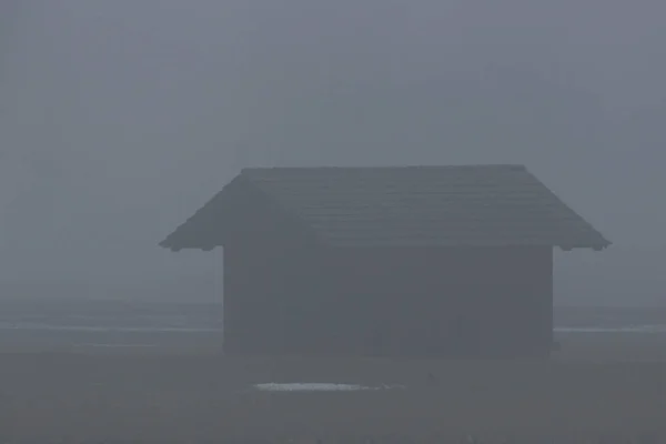 Cabana com telhado no prado com névoa — Fotografia de Stock