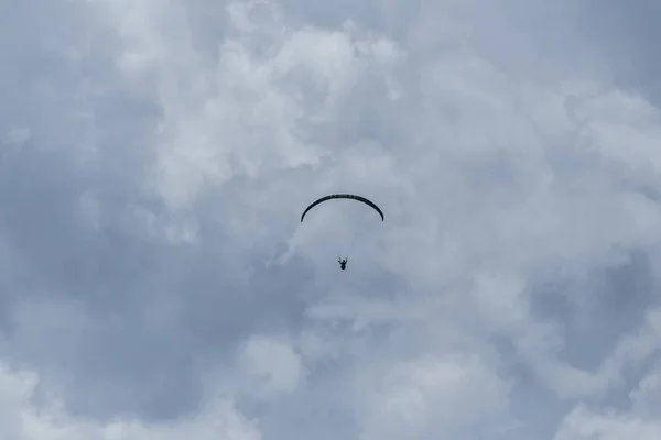 Silhouette of paraglider in dark clouds — Stock Photo, Image