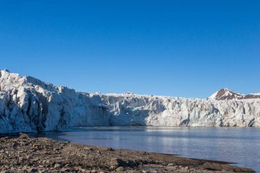 Spitsbergen'deki Esmarkbreen buzulunun buz ön cephesi, deniz, mavi gökyüzü