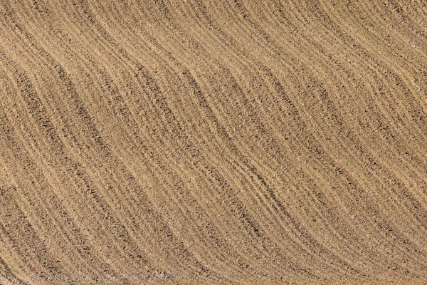 Nově zbrázděné zemědělské pozemky s symetrickými brázdnými řadami — Stock fotografie