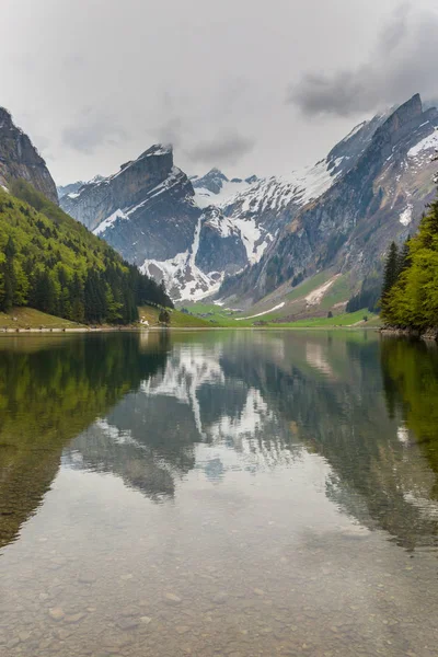 Meer Seealpsee, gespiegelde besneeuwde bergtoppen, wolken — Stockfoto