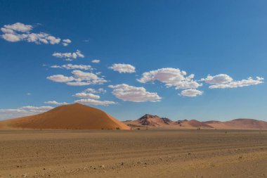 Kum tepeleri, bulutlar, mavi gökyüzü ile Namib çöl