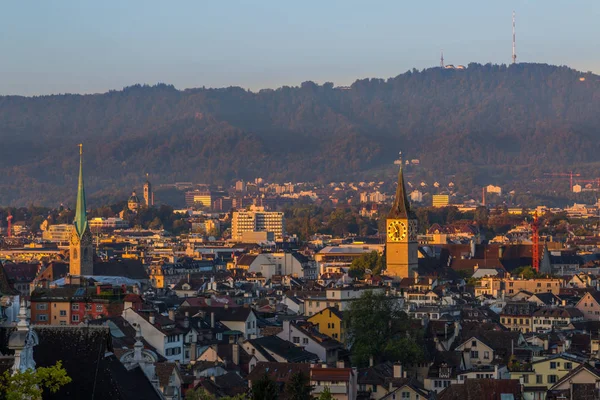 Vue du lever du soleil sur les églises, les toits et l'Uetliberg de Zurich — Photo
