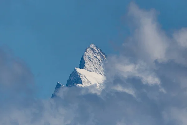 Cumbre de la montaña Finsteraarhorn en las nubes, cielo azul — Foto de Stock