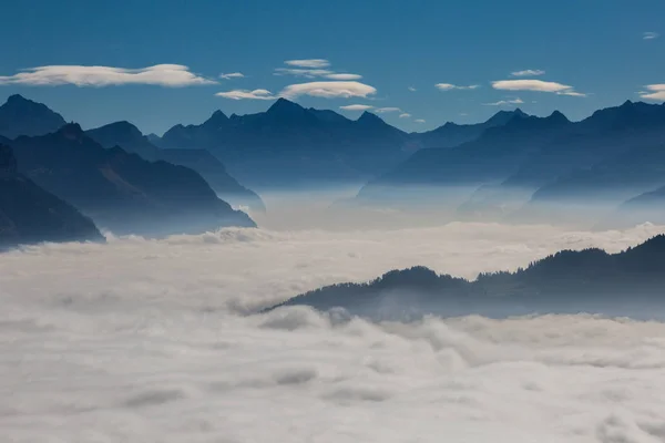 青い空のスイスの山のシュヴィーツとウリの上の霧の海 — ストック写真