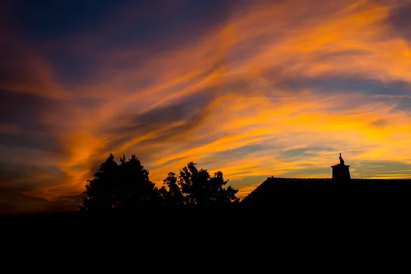 Silhouette de maison et arbre à l'aube du soir avec ciel orange — Photo