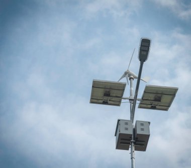 Sürdürülebilir enerji, temiz enerji ve yenilenebilir enerji için güneş ışığı kavramından elektrik üretmek üzere rüzgar türbini ve güneş paneli bir aydınlatma direğine kurulmuştur..