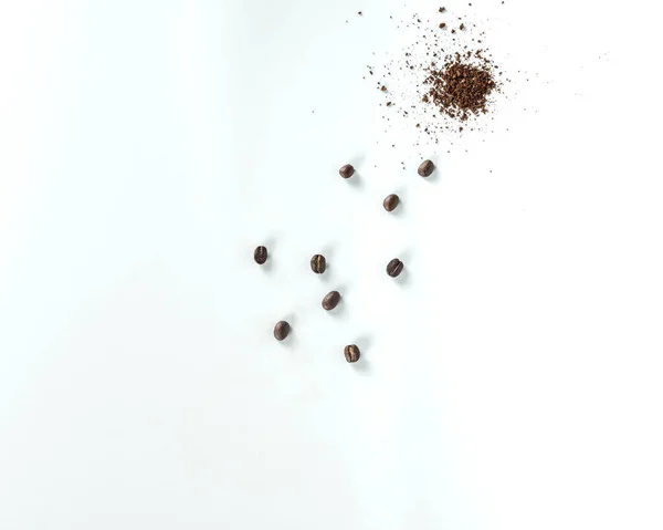 コーヒー豆の粉はコピースペースで上から見ると白い背景に隔離されて広がっています — ストック写真