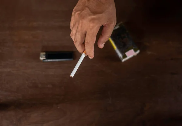 手拿着桌子为背景的香烟 癌症的概念 — 图库照片