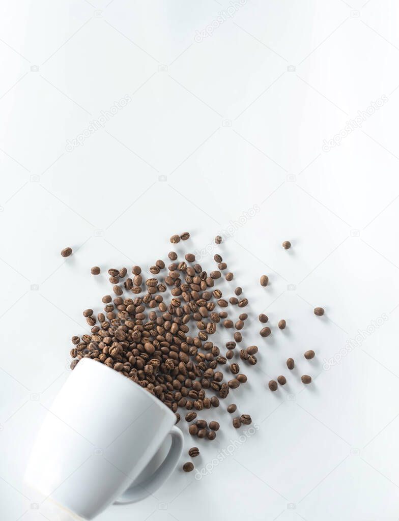 cup with coffee beans fall down isolated on white background 
