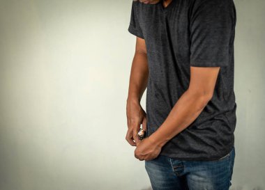 Adam duvarın arkasında yanan bir sigara tutuyor. Uyuşturucu, hastalık ve suç kavramı.