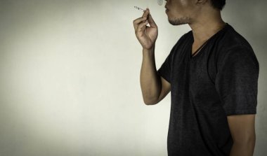 Duvarın arkasında sigara içen adam uyuşturucu, suç, hastalık konsepti.