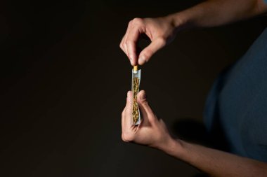 Marihuana ve tütün saran genç bir çocuğun en iyi görüntüsü.