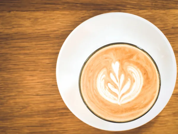 Sıcak süt kahve beyaz cam plaka ahşap masa arka plan kahverengi tonu yaşam tarzı kavramı fikri üzerine — Stok fotoğraf