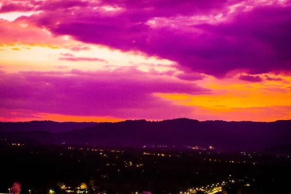 Paysage montagneux au coucher du soleil ciel nuageux aux couleurs pastel village de sérénité entre silhouettes de paysage urbain romantique fond nature — Photo