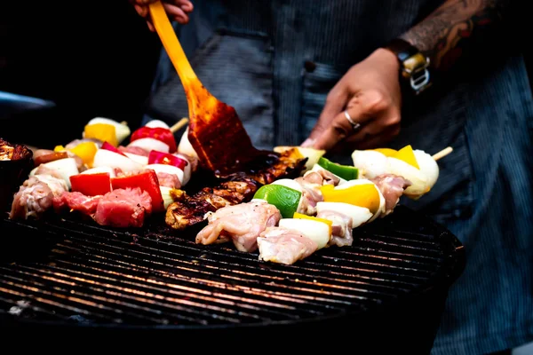 Barbecue d'été ou de printemps à l'extérieur Fermer Arrosage gourmand Barbecue sur planche à découper en bois à la table . — Photo