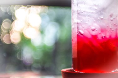 soda ile serin buz meşrubat sıvı taze gıda, ahşap masa üzerinde. Bulanık doğa arka plan ile taze fikir