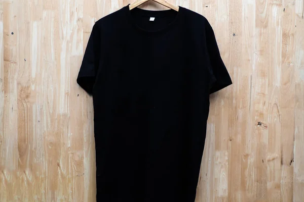 Gros plan noir t-shirt coton homme motif sur fond en bois — Photo