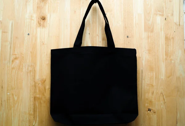 Fekete szövet táska fa háttér. Üres újrafelhasználható táska. Lapos feküdt — Stock Fotó