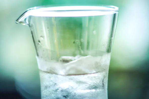 Água gelada fria no frasco de vidro transparente borrão verde natureza fundo fresco sentimento — Fotografia de Stock