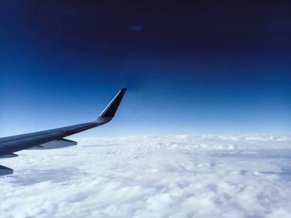 Letecký pohled z okna letadla křídlo letadla a mraky modrá obloha cestování — Stock fotografie