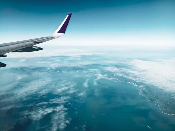 Крило хмарне небо атмосфера літак транспортний засіб авіація польоти сині хмари літак крило літака з тропічним лісом під мальовничим зеленим синім морським фоном — стокове фото