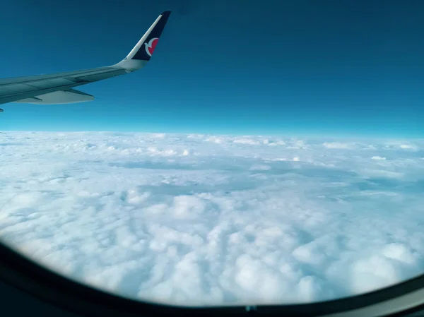 Luftaufnahme aus dem Flugzeugfenster Flugzeugflügel und Wolken — Stockfoto