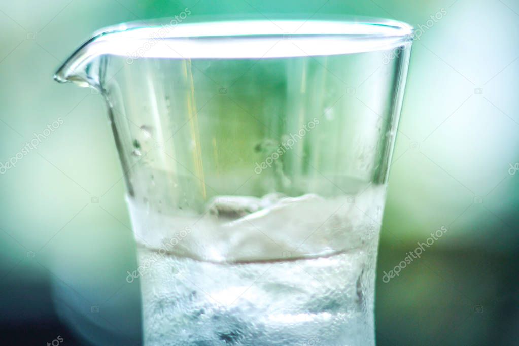 iced cold water in clear glass jar blur green nature background fresh feeling
