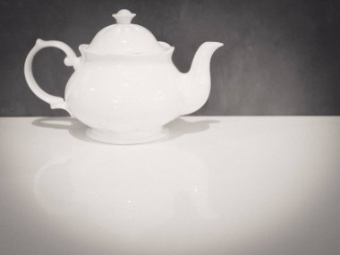 Beyaz İngiliz porselen çaydanlığı beyaz masa üzerinde Gri arka plan hoş bir ton 