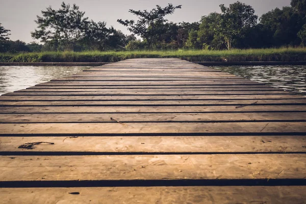 Παλιά ξύλινη γέφυρα πέρα από λίμνη στο βαθύ δάσος, φυσικό εκλεκτής ποιότητας φόντο — Φωτογραφία Αρχείου