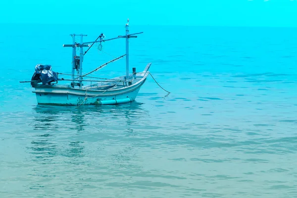 Barco de pesca perto da costa em mar azul e céu azul — Fotografia de Stock