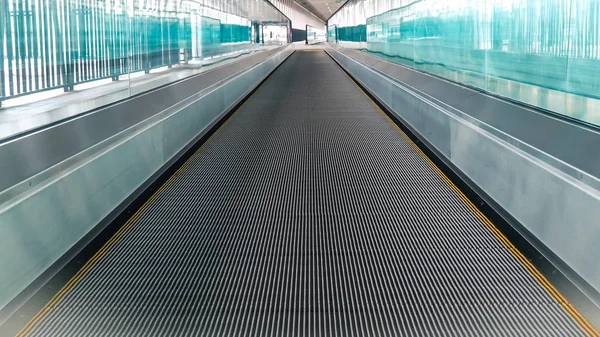 Nowoczesny chodnik schodów ruchomych przenosi się do przodu, a schody ruchome poruszają się do tyłu na międzynarodowym lotnisku. Schody ruchome to obiekt do transportu wspomagającego — Zdjęcie stockowe
