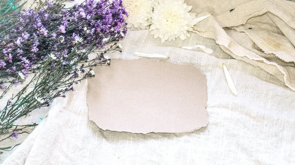 Boş zanaat kağıt ve çiçek dekorasyon. Beyaz bir doğal tebrik kartı; keten arka plan