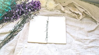 Boş beyaz kağıt defter ve çiçek dekorasyonu. Beyaz bir doğal tebrik kartı; keten arka plan