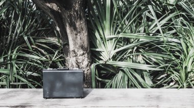 Yeşil doğa arka plan ile ahşap yüzey üzerinde siyah iş deri evrak çantası