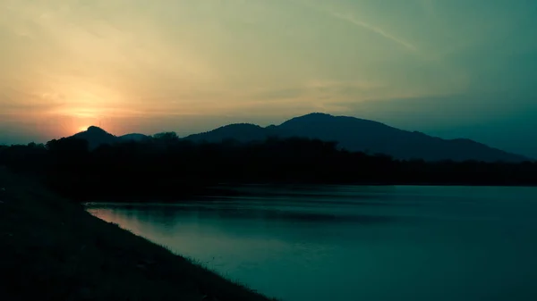 Turuncu Gökyüzü Dağlar Tepeler Ağaçlar Göl Siluetleri Ile Günbatımı Manzara — Stok fotoğraf