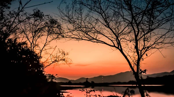 山和森林湖的日落剪影与橙色的风景 — 图库照片