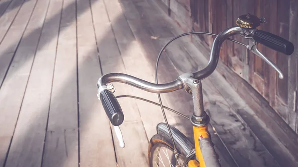 Bicycle handle bar close up. Vintage filter. wooden floor background. Good old day concept. Holiday idea.