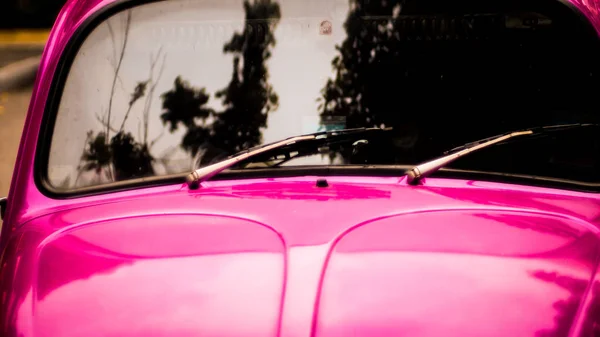 太陽漂白ピンクのヴィンテージ自動車の後部フロントガラスワイパーアームとブレードのクローズアップ — ストック写真