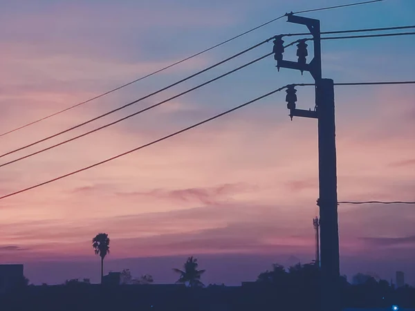 夕焼けオレンジの空の電柱と電圧器 — ストック写真