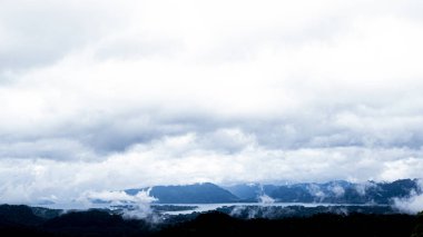 sonbaharda karla kaplı dağların panoramik drone görünümü, Kanchanaburi Tayland kaplı sis içinde göl ile İsviçre alpleri üzerinde havadan görünümü