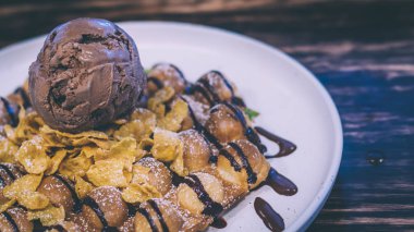 Waffle çikolatalı dondurma, muz ve silme krema sıcanda tepesinde . Çikolatalı kahve dondurma topu